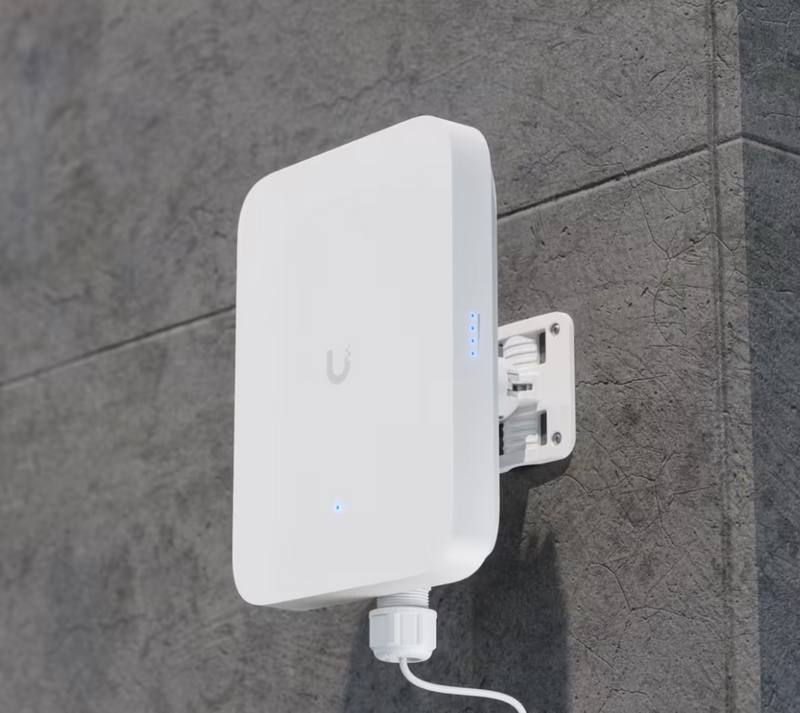 Ubiquiti U5G-Max-Outdoor UniFi 5G Max Outdoor mounted on an exterior wall with an adjustable bracket and cable routed through the bottom gland.