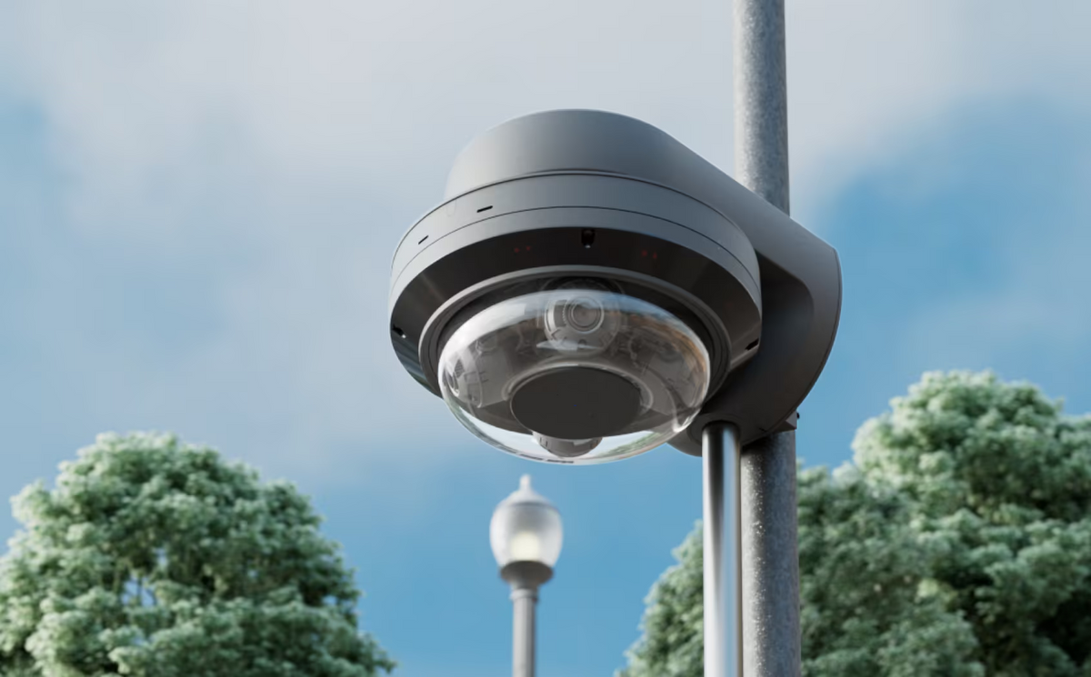 Ubiquiti UACC-AI-MS-4-AM-B UniFi AI Multi Sensor 4 black camera arm mount installed on an outdoor pole with a dome camera and bottom-entry conduit.