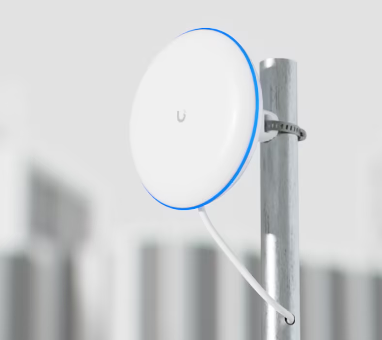 Ubiquiti UBB UniFi Building Bridge installed on a metal pole with mounting strap and connected network cable
