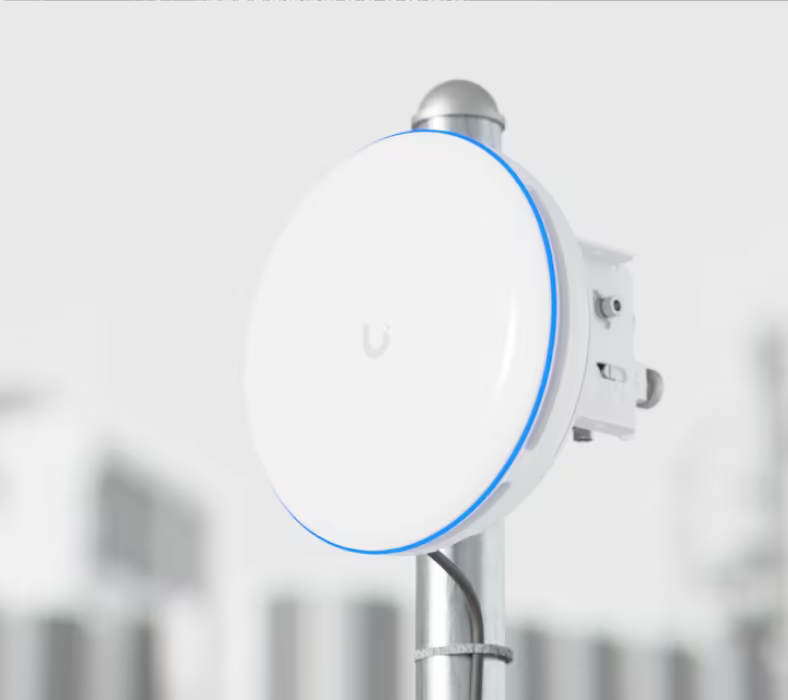 Ubiquiti UBB-XG UniFi Building Bridge XG installed on an outdoor pole with its blue alignment LED illuminated