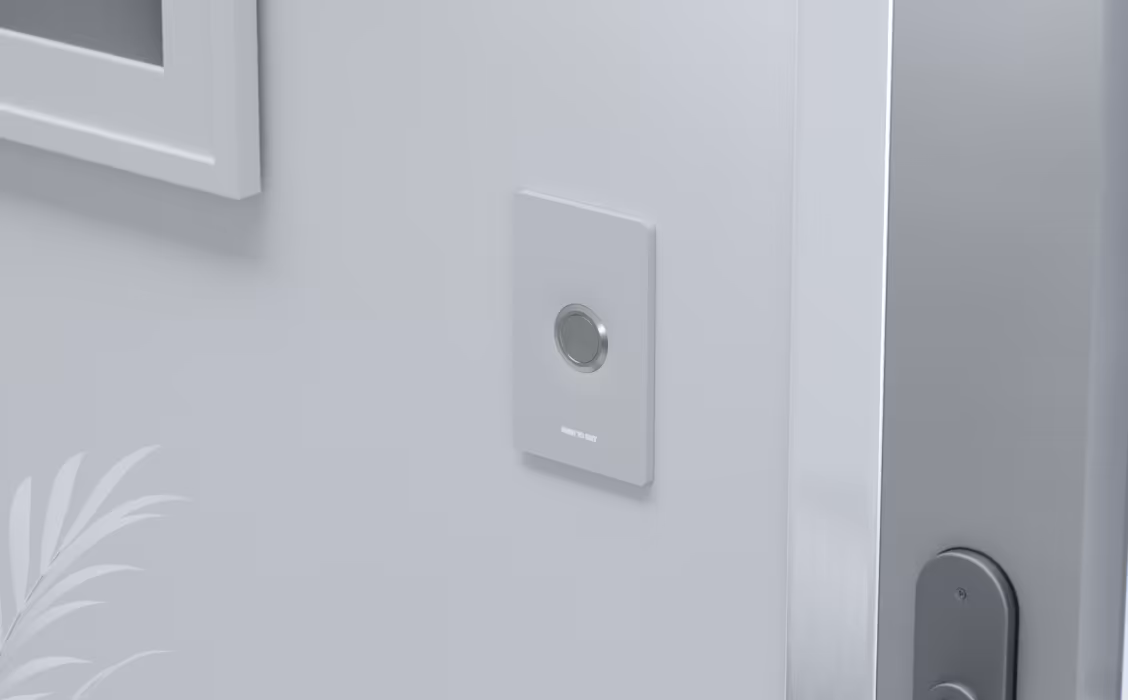 White Ubiquiti UA-Button UniFi Access Button mounted beside a door with a silver push-to-exit button.