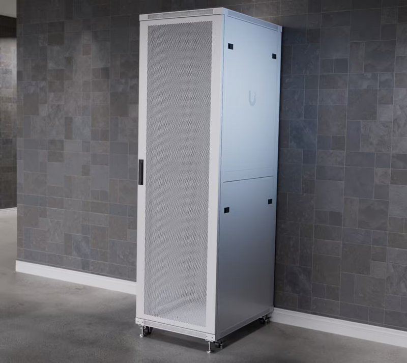 Ubiquiti UniFi 800mm 42U rack cabinet installed indoors with white perforated front door and caster wheels