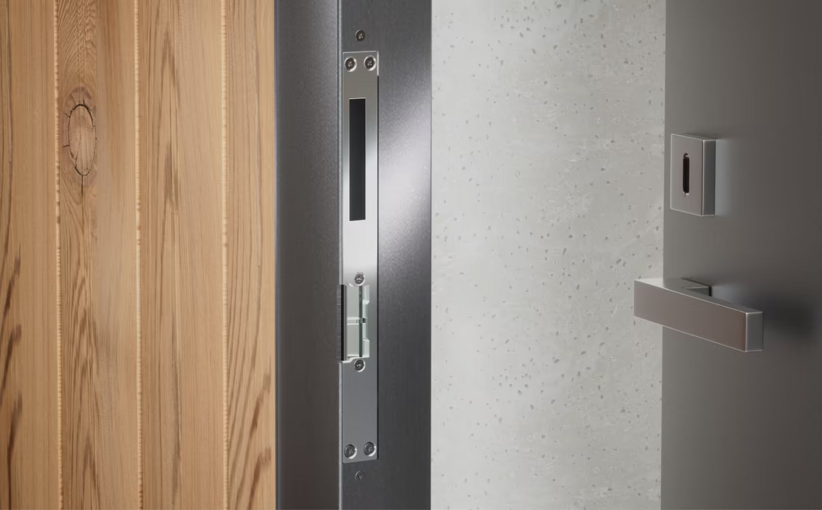Ubiquiti UACC-Lock-Strike-Safe-8mm UniFi fail-safe strike lock installed in a dark metal door frame with the long front plate and latch opening.