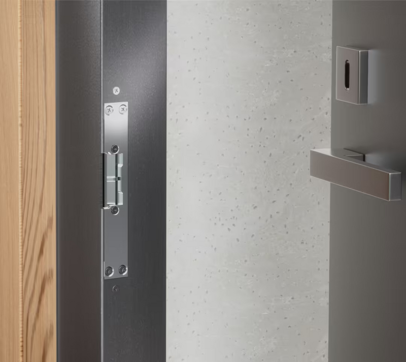 Ubiquiti UACC-Lock-Strike-Secure-8mm UniFi Narrow 8mm Fail-Secure Strike Lock installed with the short front plate in a dark metal door frame.