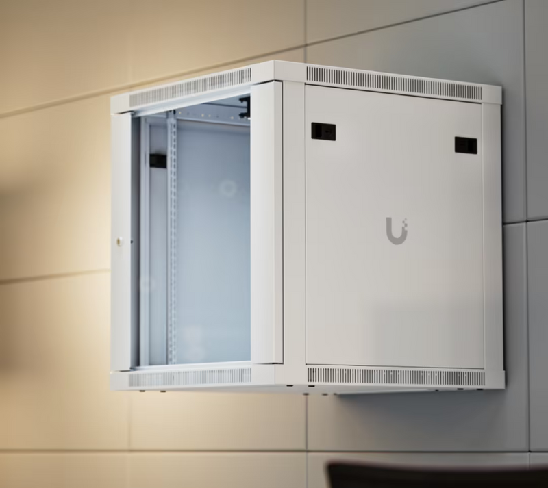 Ubiquiti UACC-Rack-12U-Wall-600-G UniFi Standard 12U rack cabinet installed on a wall, with a tempered glass front door, ventilated frame and lockable side panel.