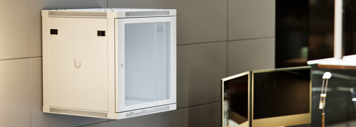 Ubiquiti UACC-Rack-12U-Wall-600-P UniFi 12U Rack Cabinet wall-mounted in a modern office with perforated front door and lockable side panel