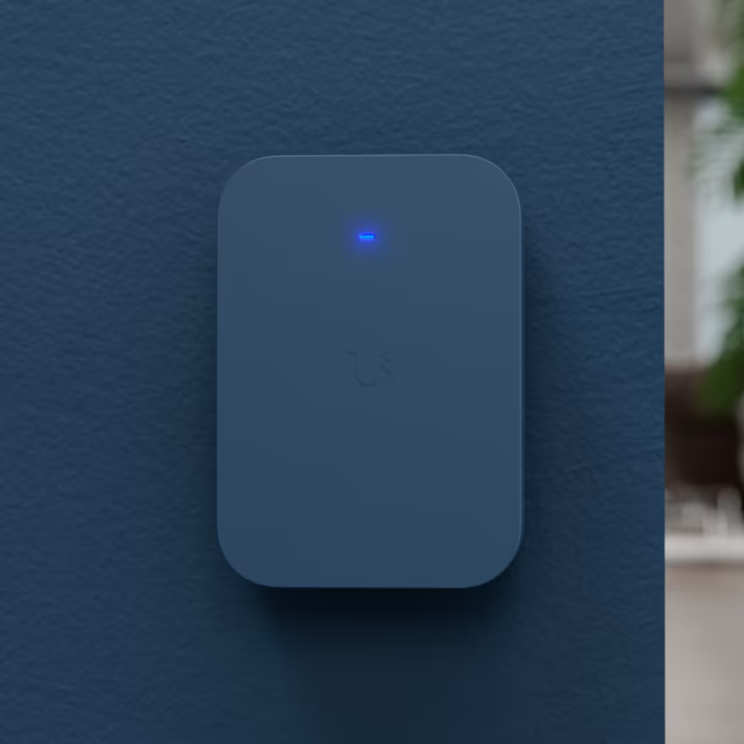 UniFi U7 Pro XG Wall Paintable Cover colour-matched to a dark blue wall with blue status LED