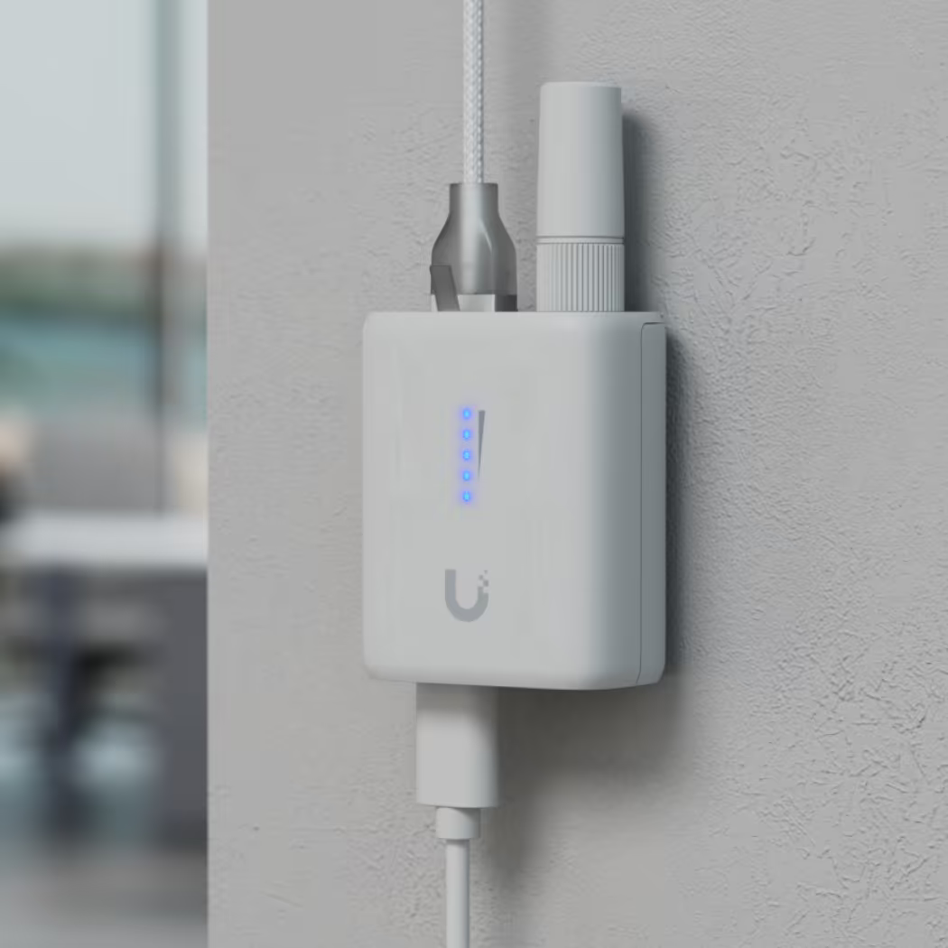 Wall-mounted Ubiquiti UniFi UDB-IoT Device Bridge IoT with antenna, connected cables and illuminated status LEDs