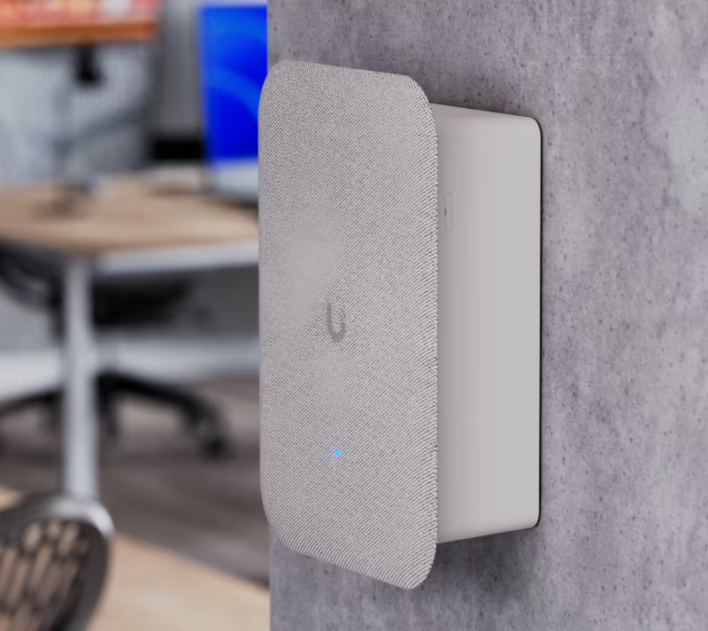 Ubiquiti UP-AI-Speaker UniFi AI Speaker surface-mounted on a concrete office wall