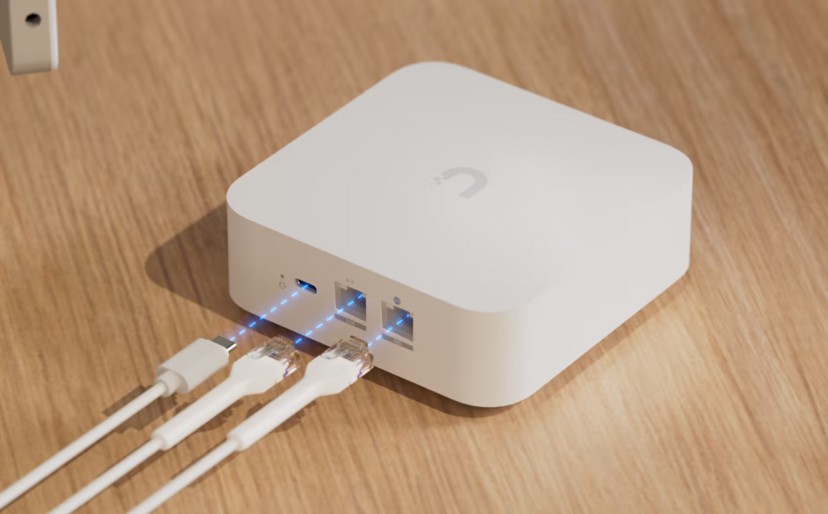 Ubiquiti UX7 UniFi Express 7 rear view showing USB-C power and two Ethernet ports, with cables aligned for connection.